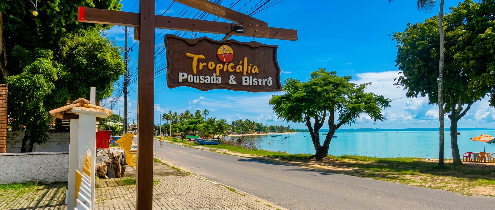 Placa da Pousada Tropicália em frente à praia de Ponta de Areia com mar azul-turquesa
